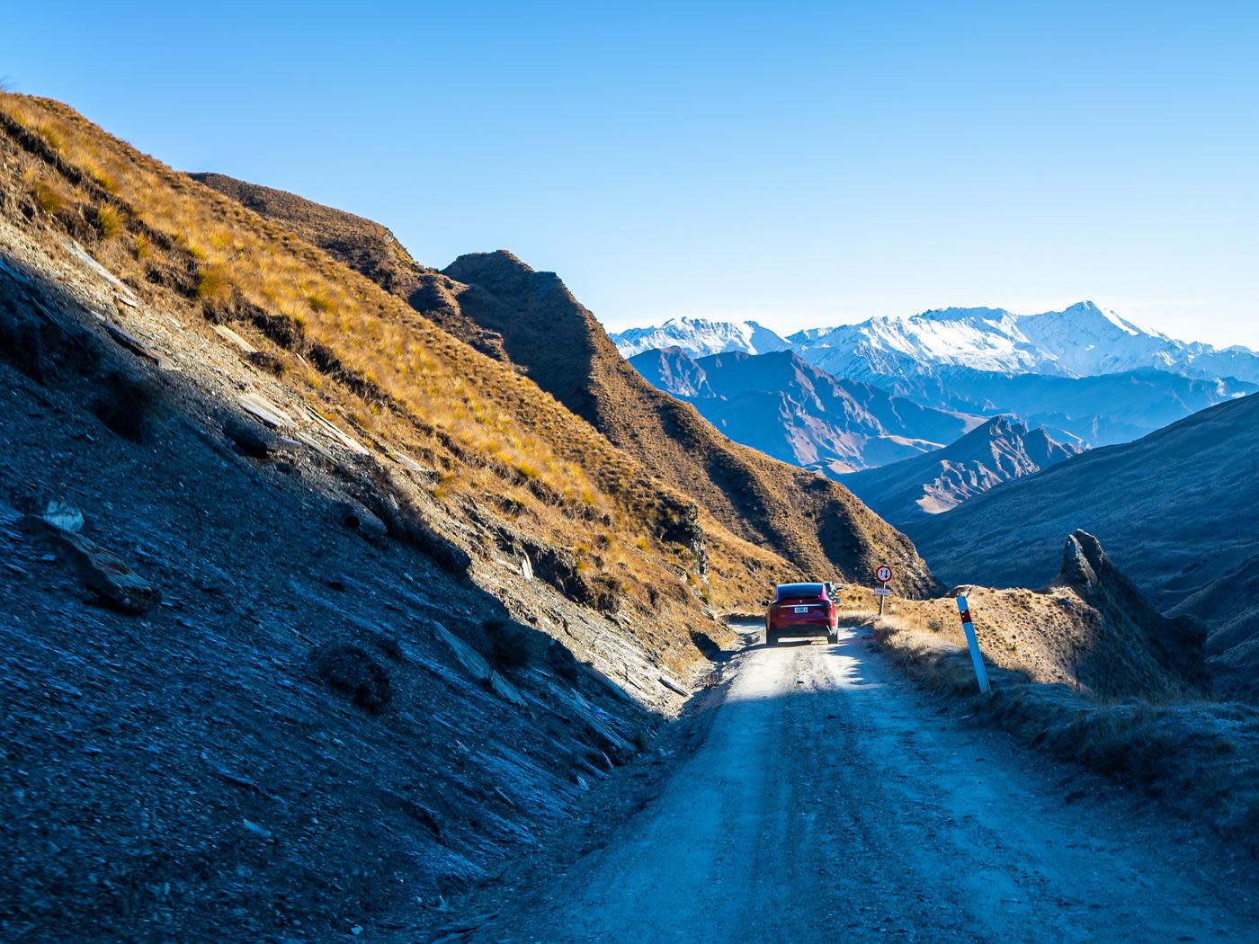 Tesla driving down Skippers Road with mountains in background