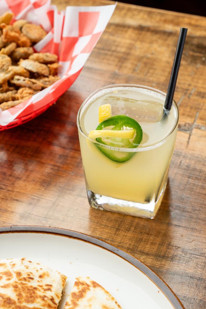 A Smoke & Sunshine at Lankford's looks like a lemon slush, topped with a fresh jalapeno slice. A lemon rind is curled through the "eyes" of the jalapeno.