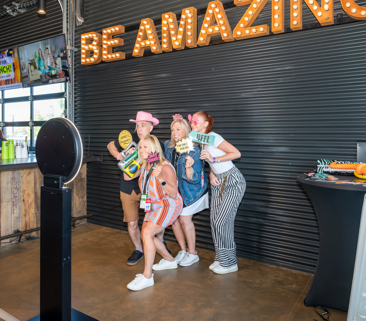 Meeting planners pose for a selfie at a photo booth at Chicken N Pickle