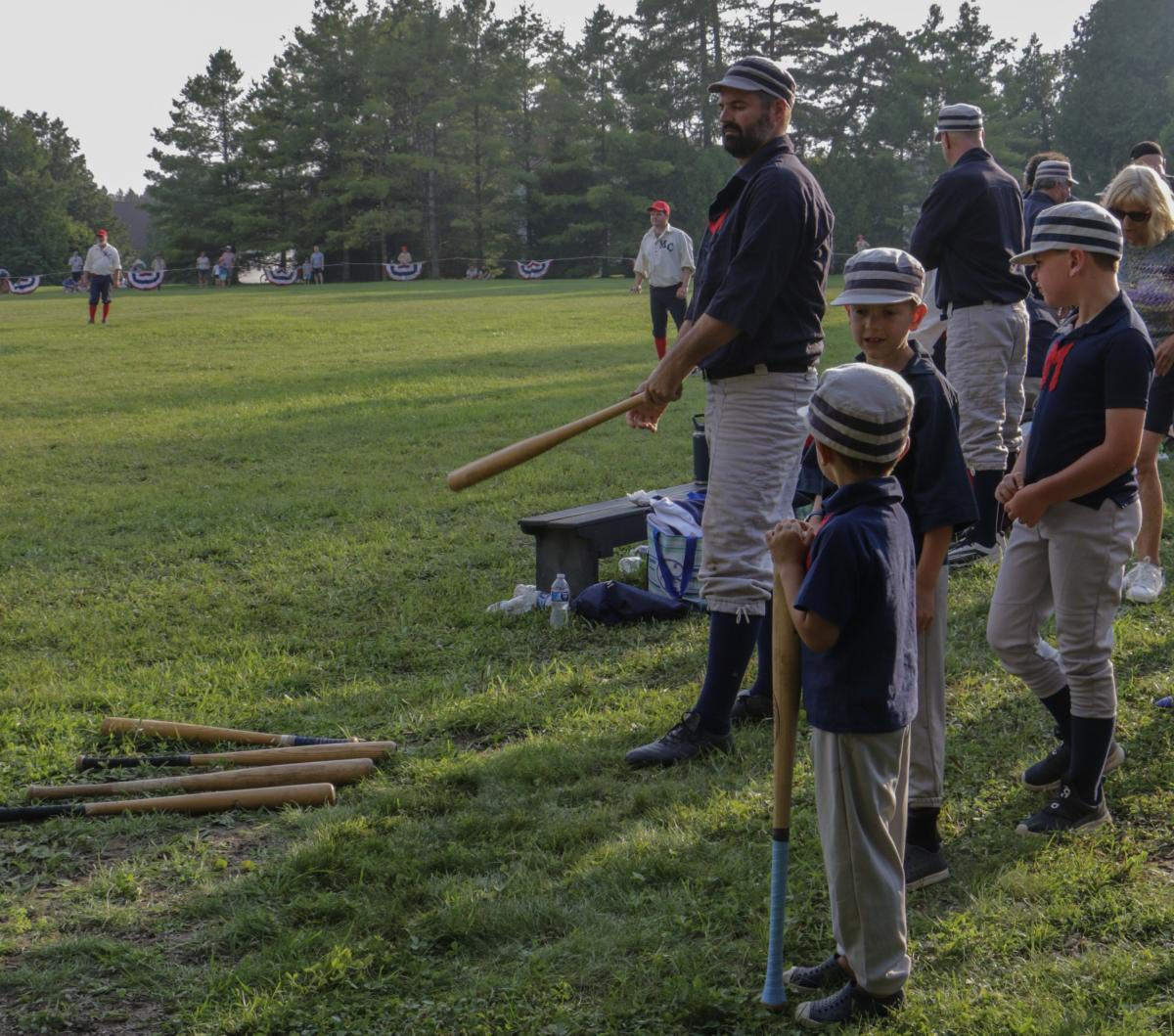 Bat boys stand near the bench during a vintage base ball game on Mackinac Island