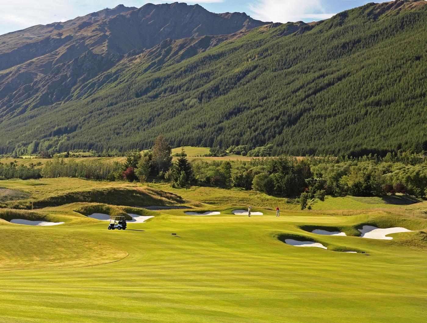 Golfers playing at Millbrook Resort with mountains behind them