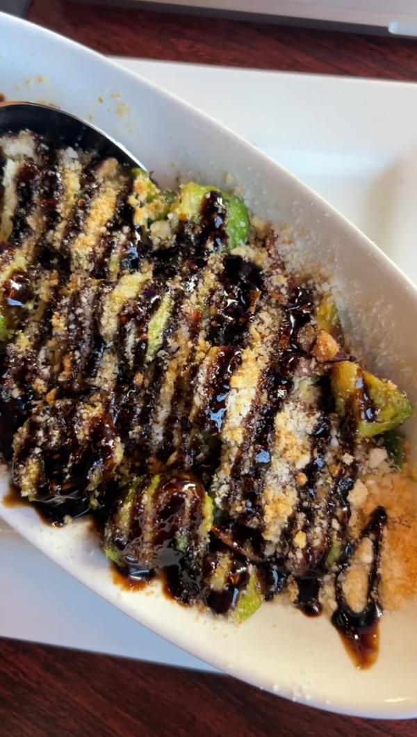 Plate of brussel sprouts covered in balsamic and parmesan