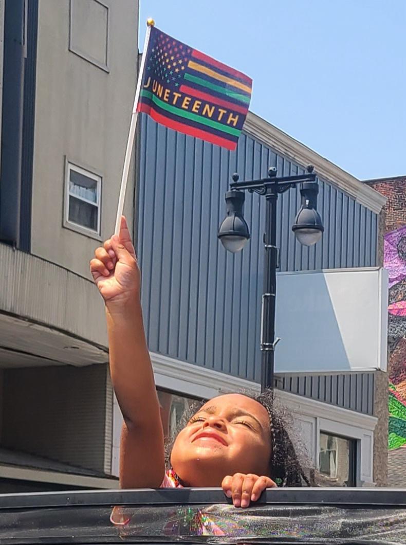 Little girl waving the Juneteenth flag