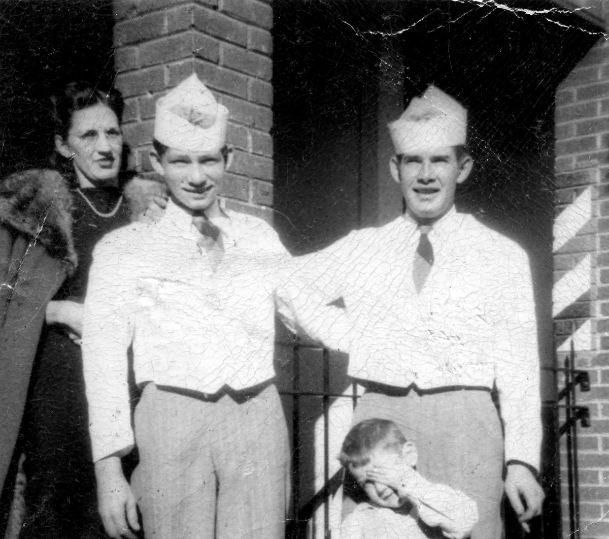 Nancy Canipe with Hugh Moon and Bill Childers, in paper caps and white shirts, outside Velt’s Cafe in Sylva, NC, in 1950, beside a barber pole
