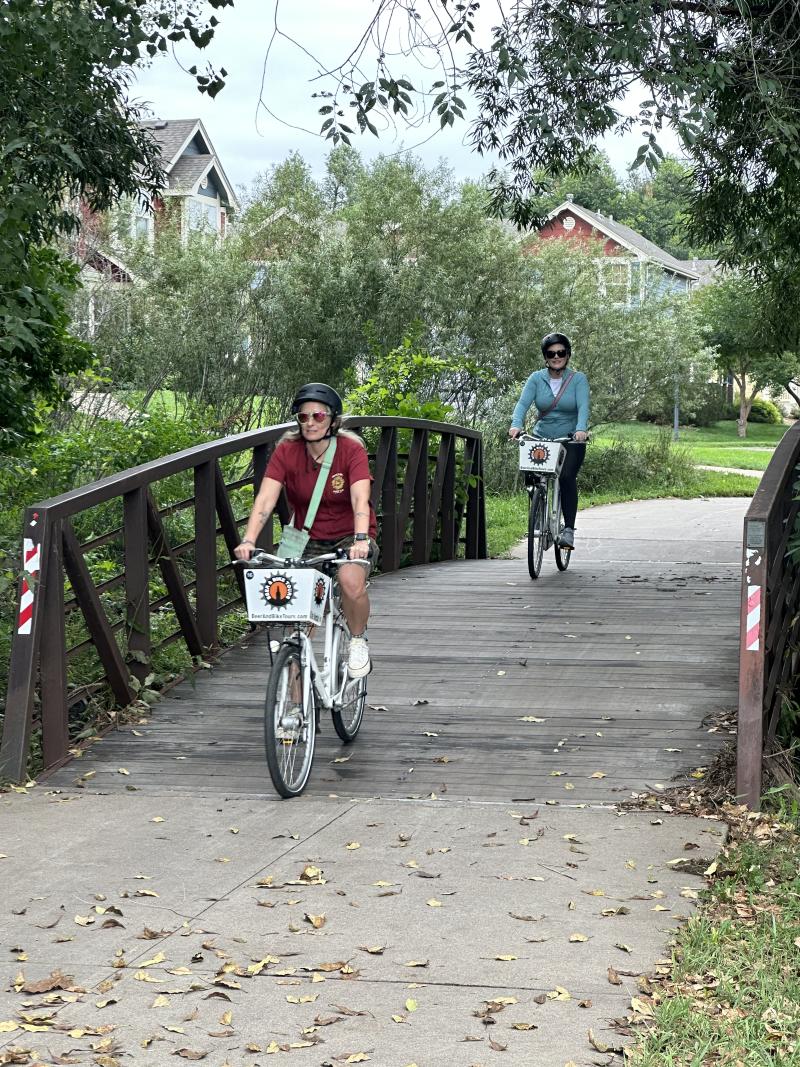 two people riding on a bridge on a beer and bike tour