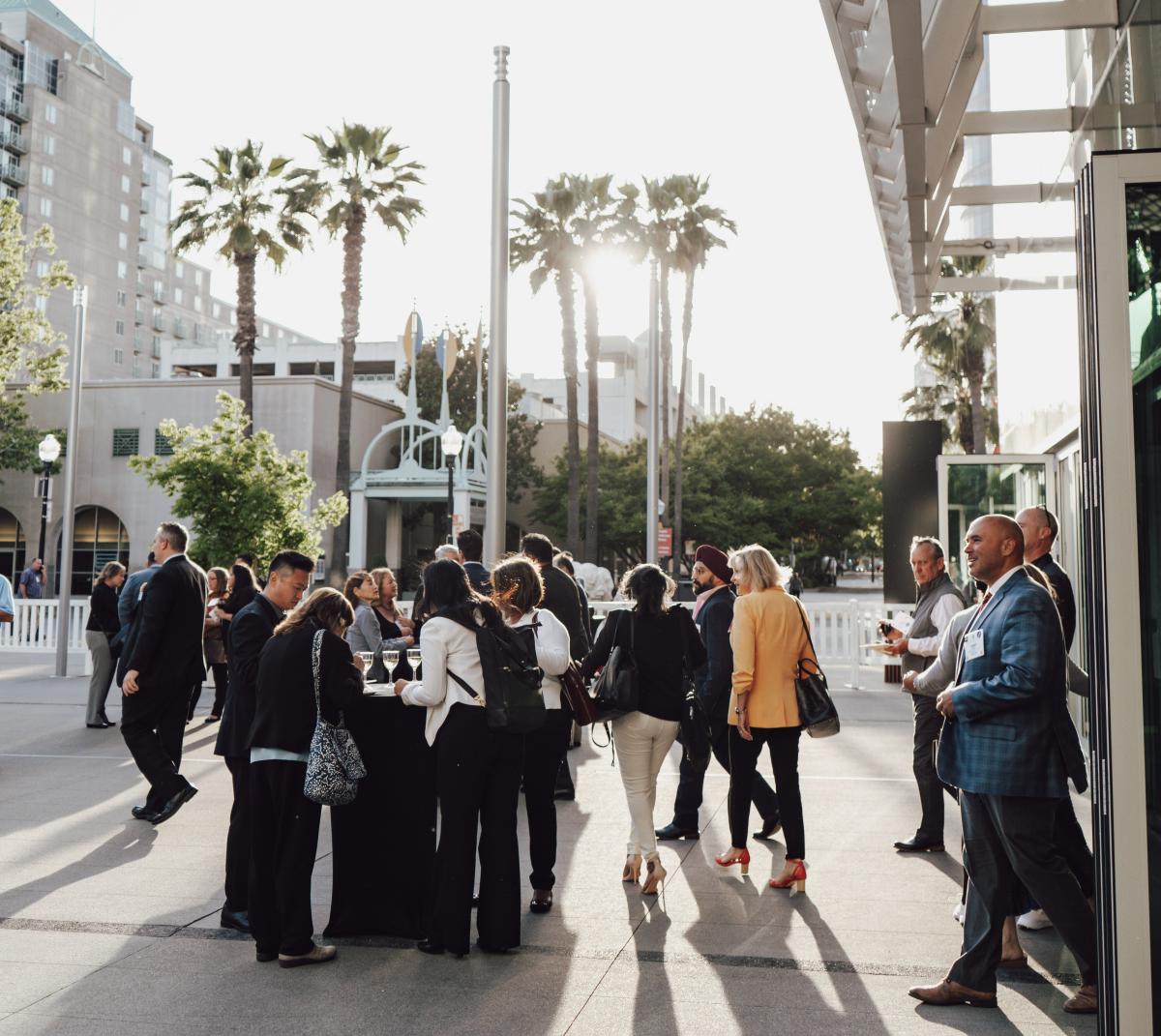 people standing outside of the SAFE credit union convention center with palm trees in the background