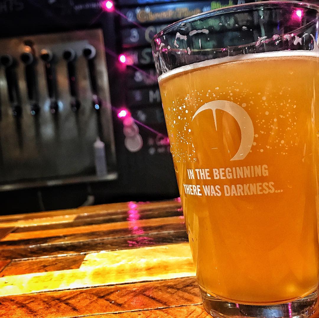 glass of beer reading "in the beginning there was darkness" with a moon graphic at darkness brewing in bellevue ky