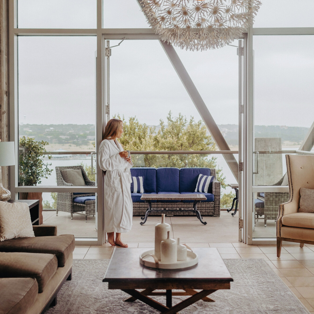 Woman standing in the doorway in a robe looking out over the lake at the Spa at Lakeway.