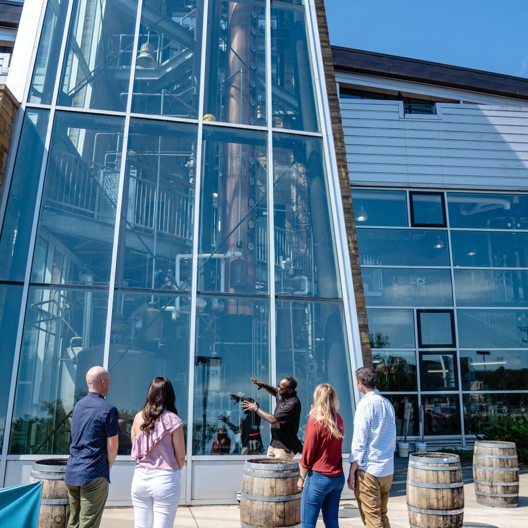 A man showing a group of people the column still at New Riff Distilling