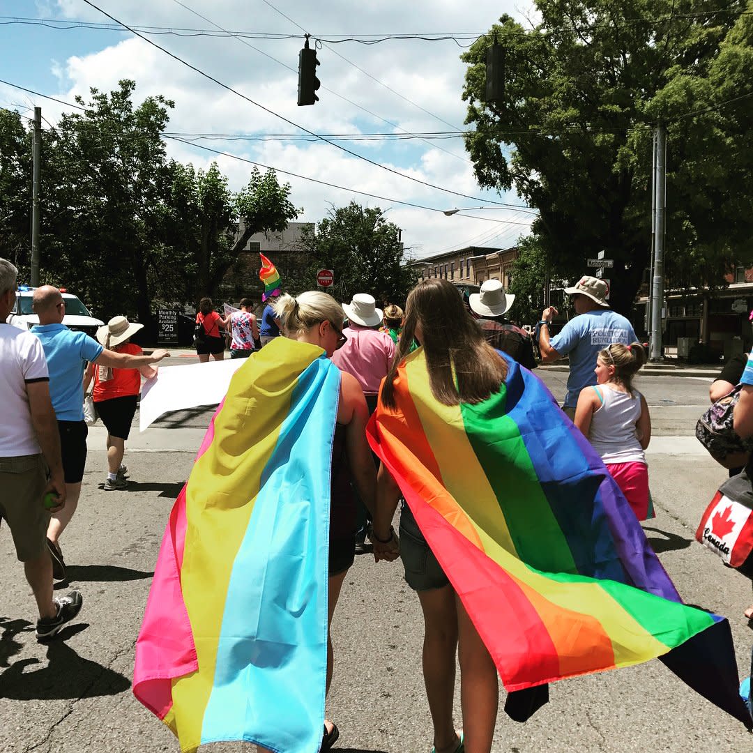 Two young people wearing Pride flags at NKY Pride in Covington Kentucky