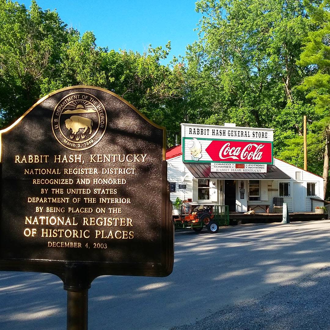 A brown sign noting that Rabbit Hash Kentucky is on the National Historic Register in front of the famous Rabbit Hash General Store