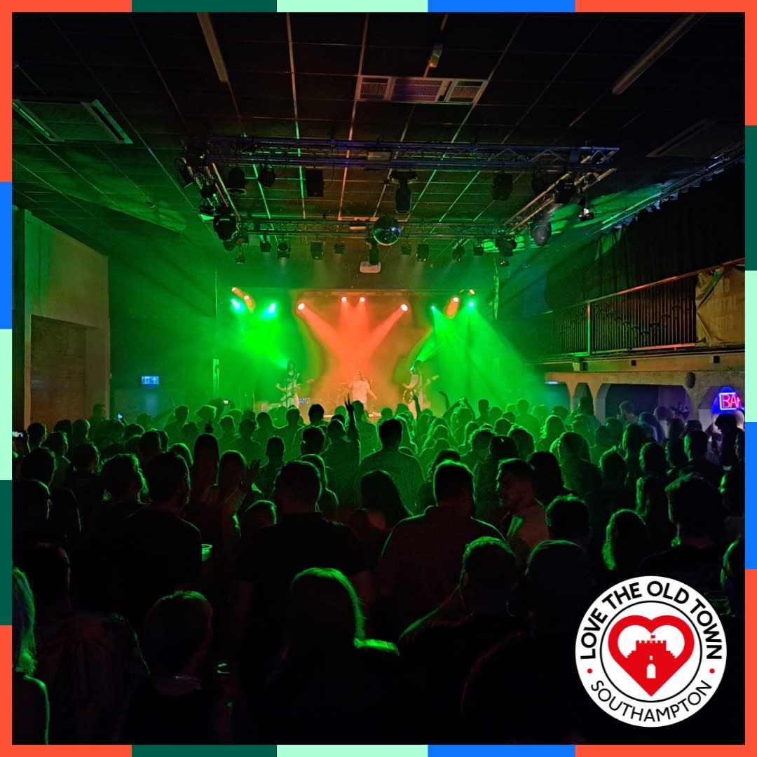 Large crowd standing in front of stage during a performance at The 1865