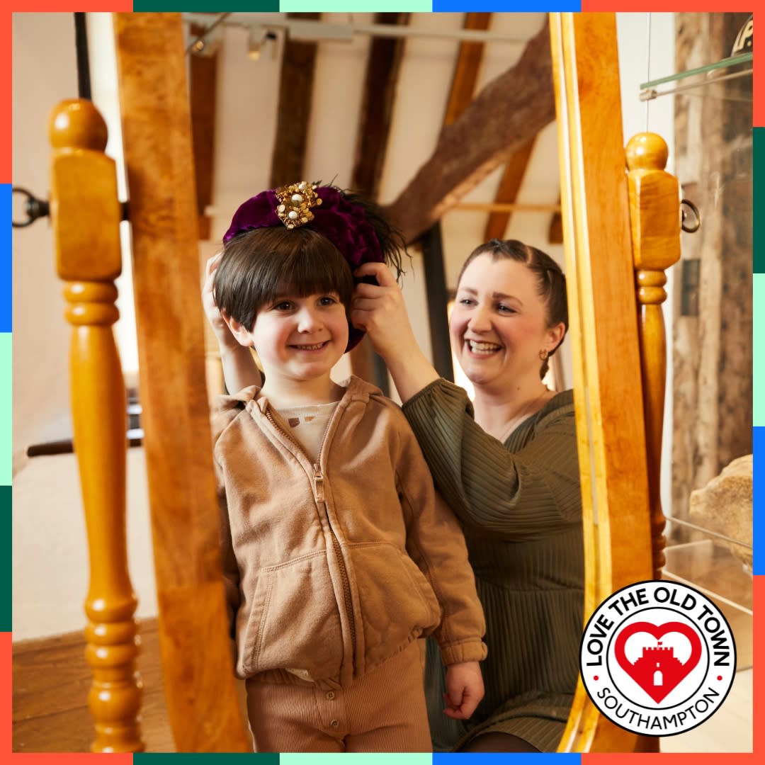 Mother and son playing fancy dress up in front of mirror at Tudor House and Garden