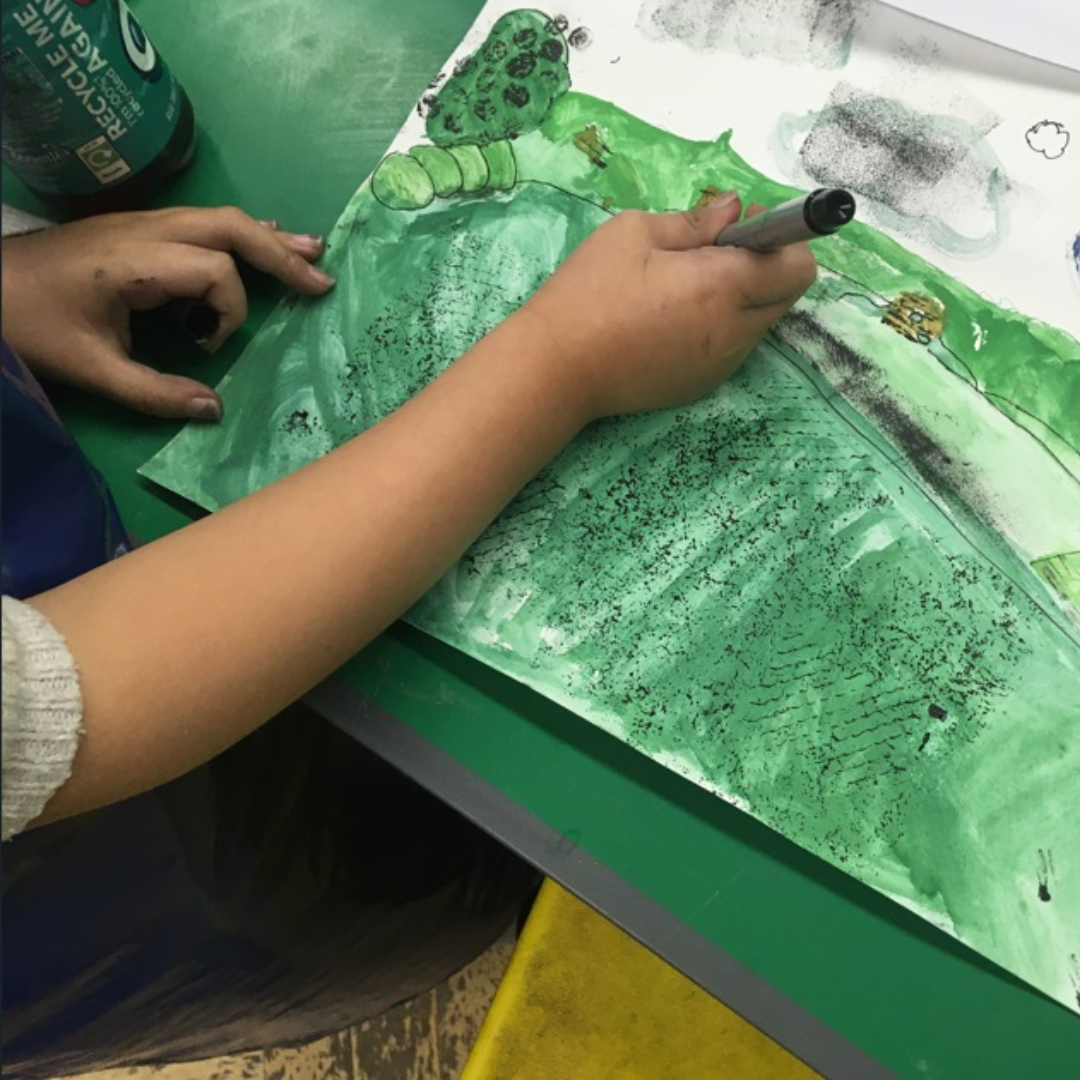 Person drawing a picture with a marker at an art workshop