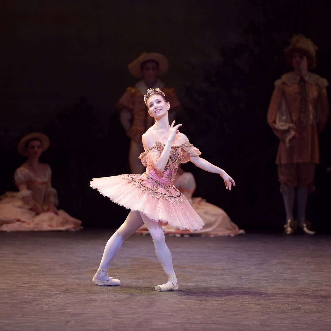 Ballet dancer dressed in pink dress on stage performing Sleeping Beauty