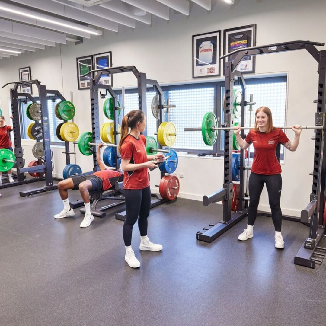Students lifting weights inside Solent University Sports Complex