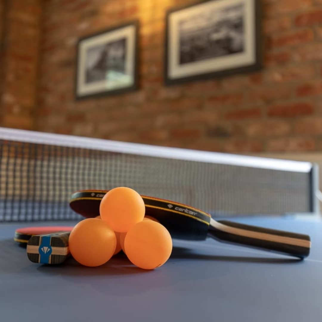 ping pong balls and rackets resting on a ping pong table at The Mayflower Village