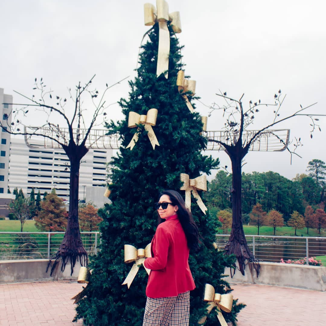 Reesa Rei in front of a Christmas tree