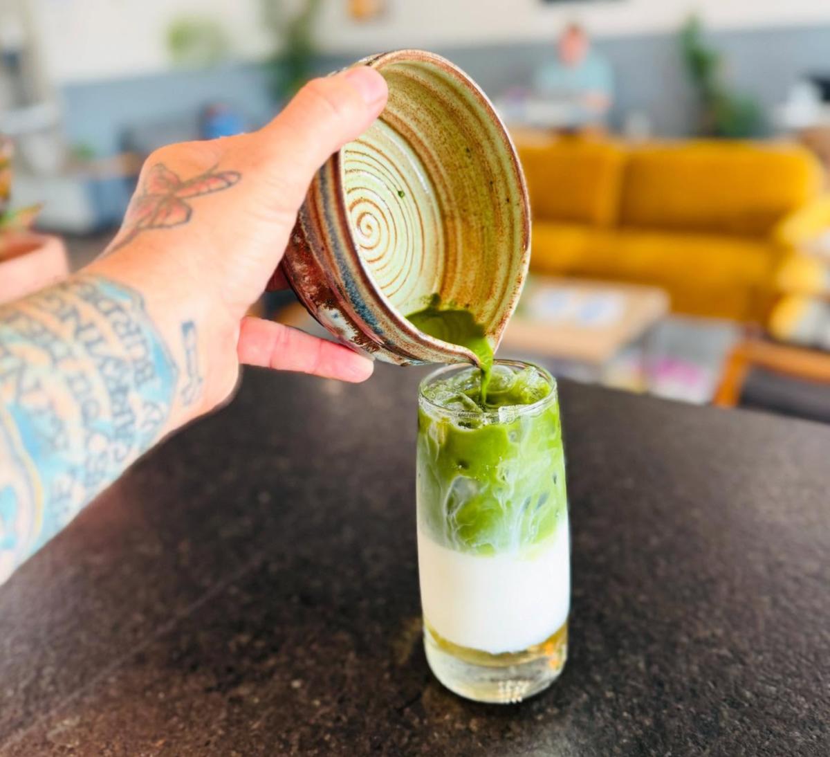 A barista pours matcha into a matcha latte at Catalyst Coffee Co.