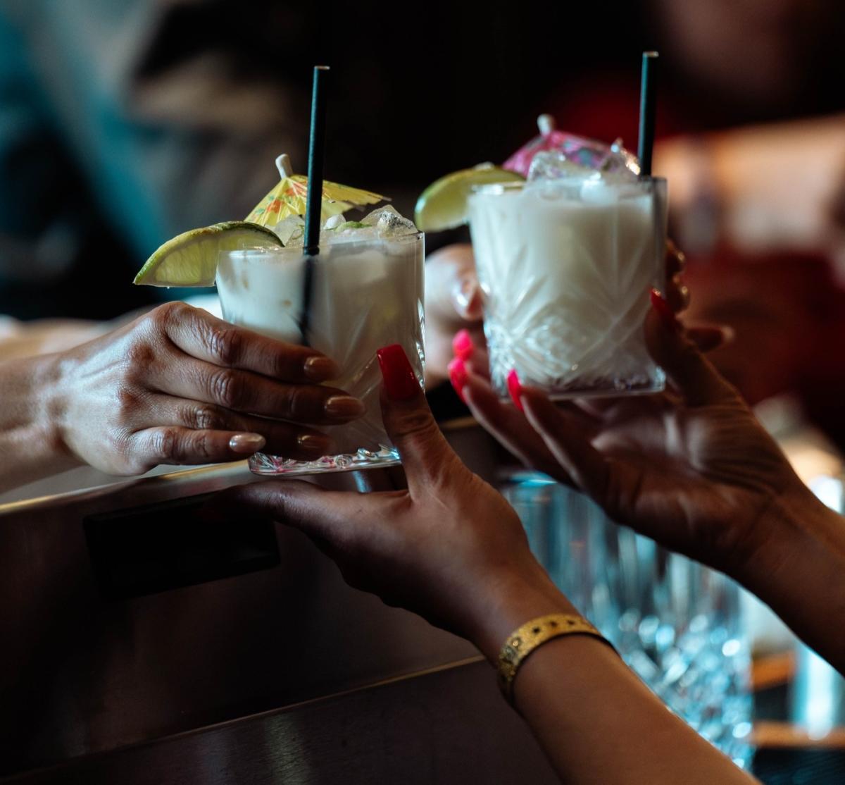 Someone hands a woman two Brazilian limeades from G. Toti.