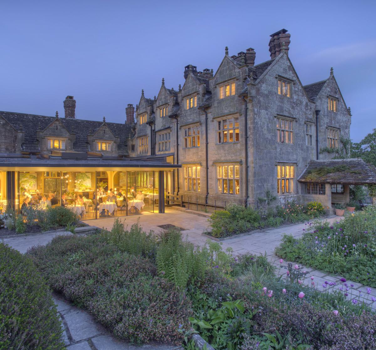 External view of Graveytye Manor and restaurant from the gardens, taken in the evening