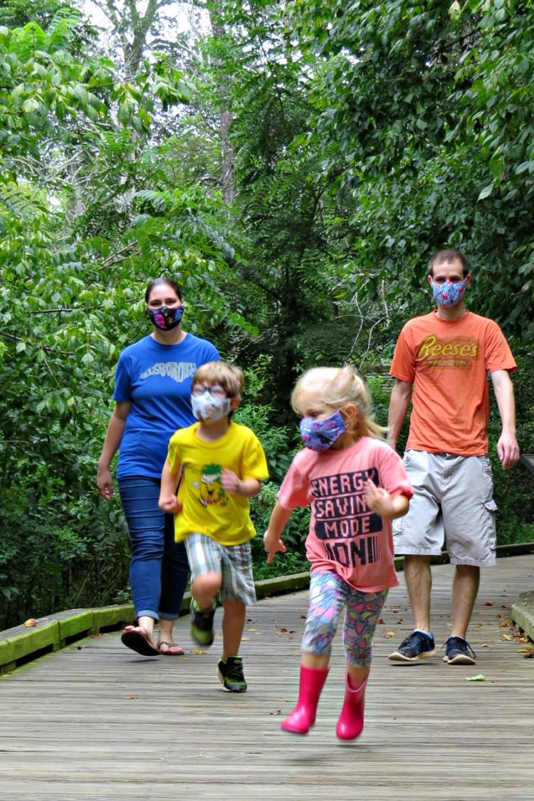 Family walking along Riverwalk, wearing masks under COVID19 mandates