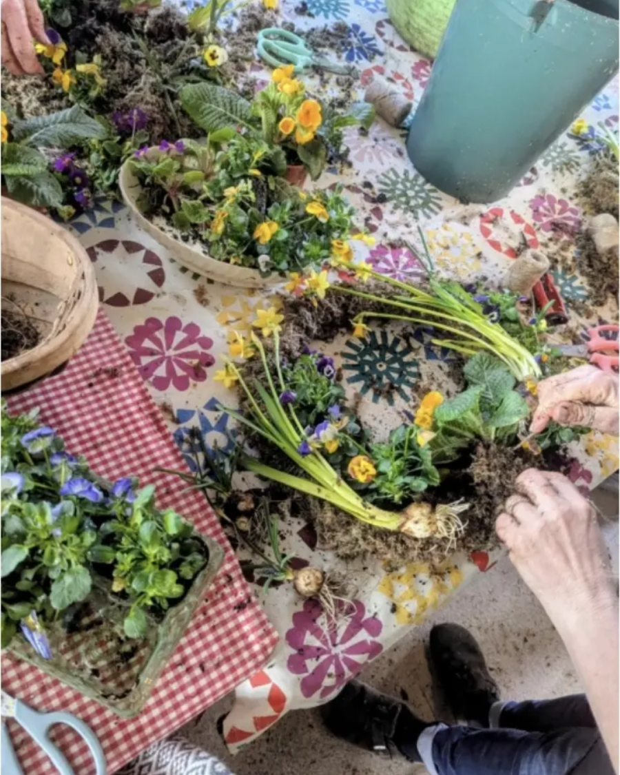 A ladies hands making a wreath with spring flowers