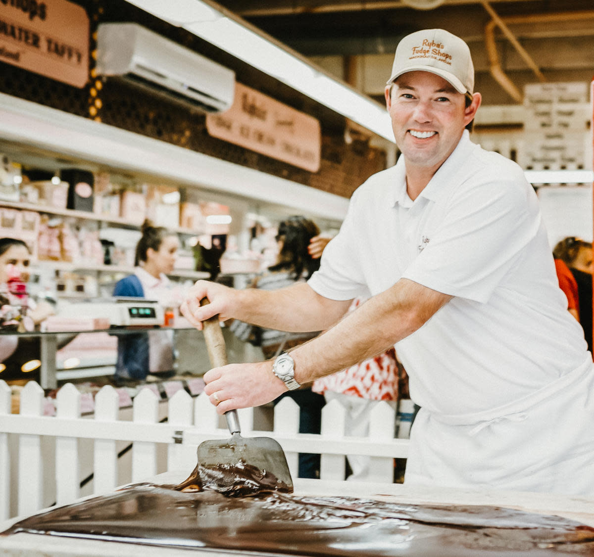 A Ryba’s Fudge Shops fudgemaker paddles gooey fudge on a marble slab