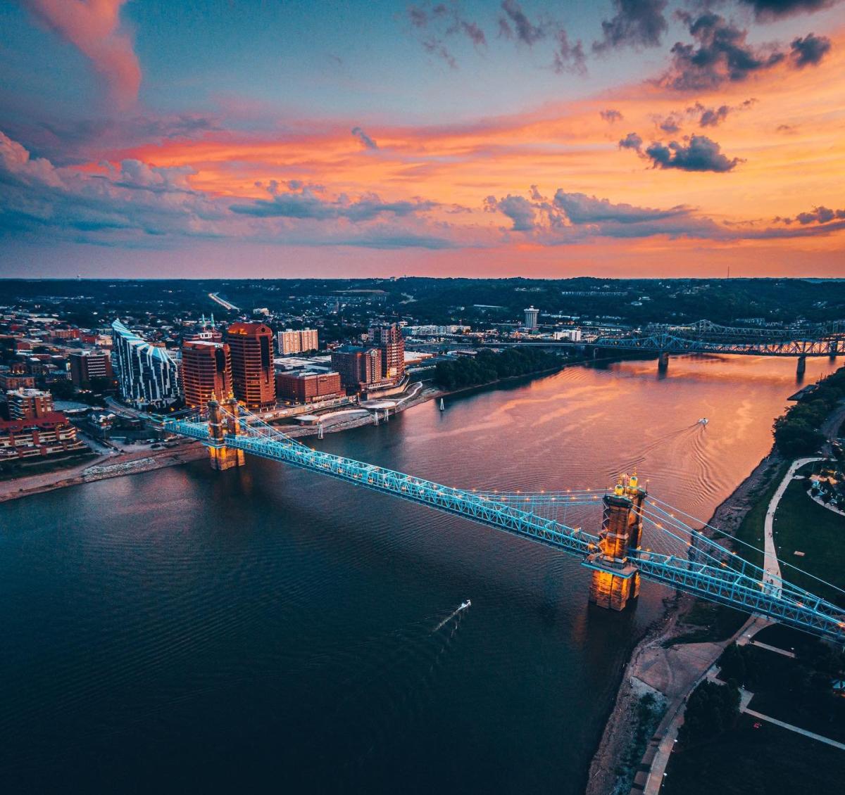 Sunset in the background over the Ohio river with the John A. Roebling Suspension bridge spanning from NKY to Cincy