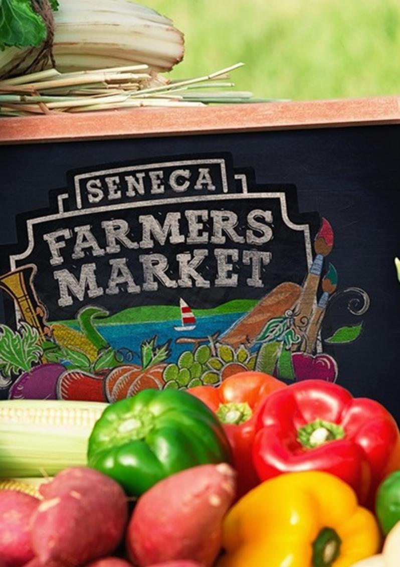 Chalk sign sitting in the middle of a spread of produce that says Seneca Farmers Market