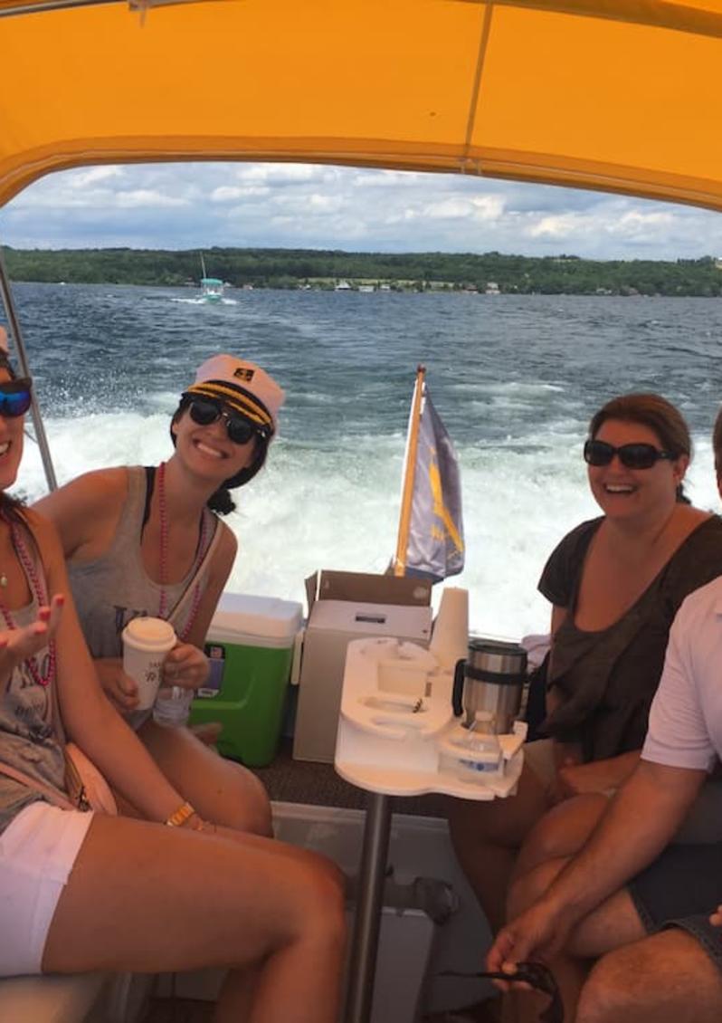 Four people riding in a boat on way to wine tour