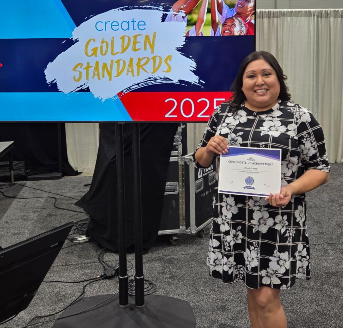 Angela poses with her STS certification she received at Sports ETA.
