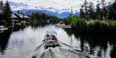 Boat passing through the channel between Shadow Mountain Reservoir and Grand Lake with Mount Craig in the background