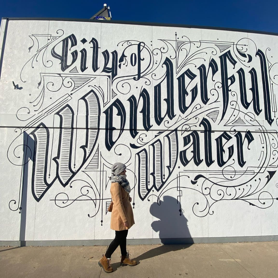 Woman walking and looking at downtown murals