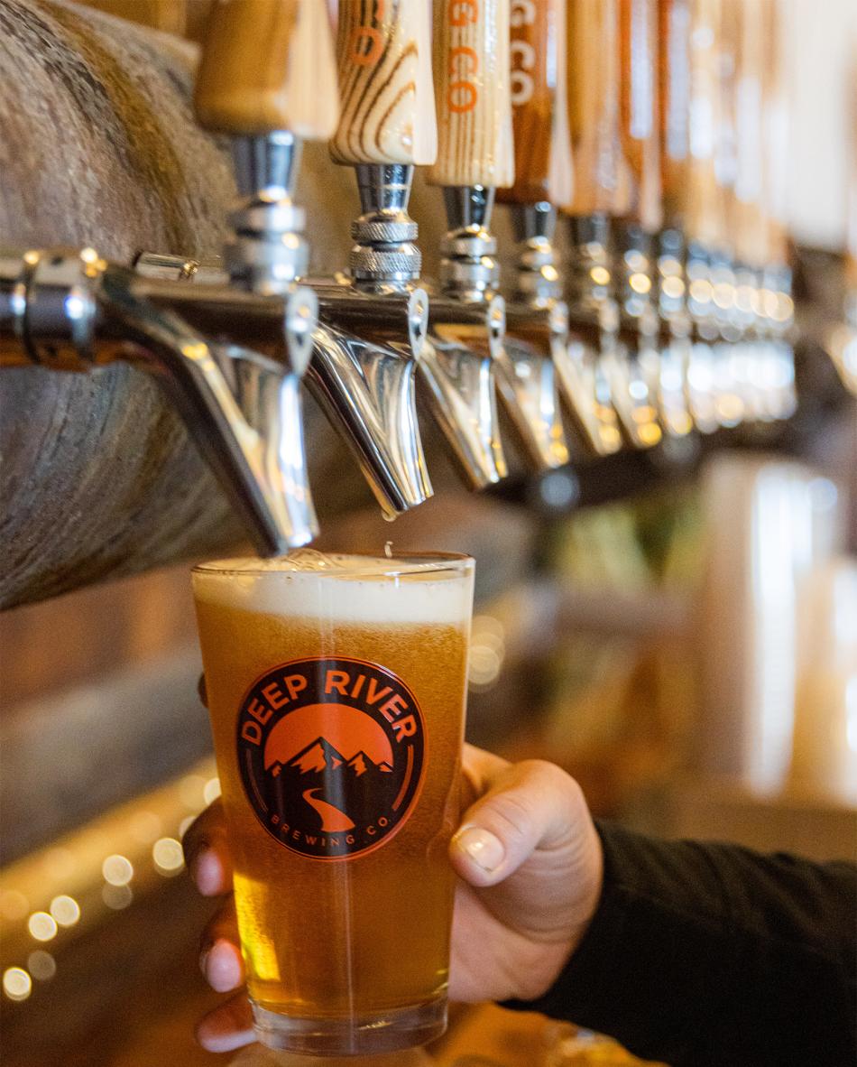 Beer taps pouring at Deep River Brewery in Clayton, NC.