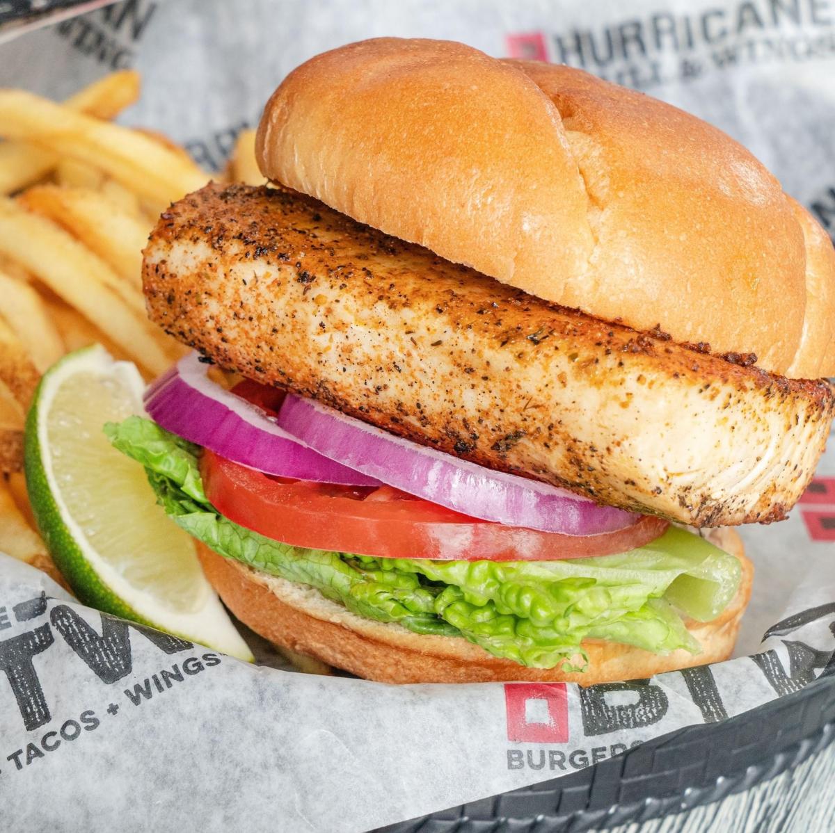 A chicken sandwich is served with a side of fries at Hurricane Sports Grill