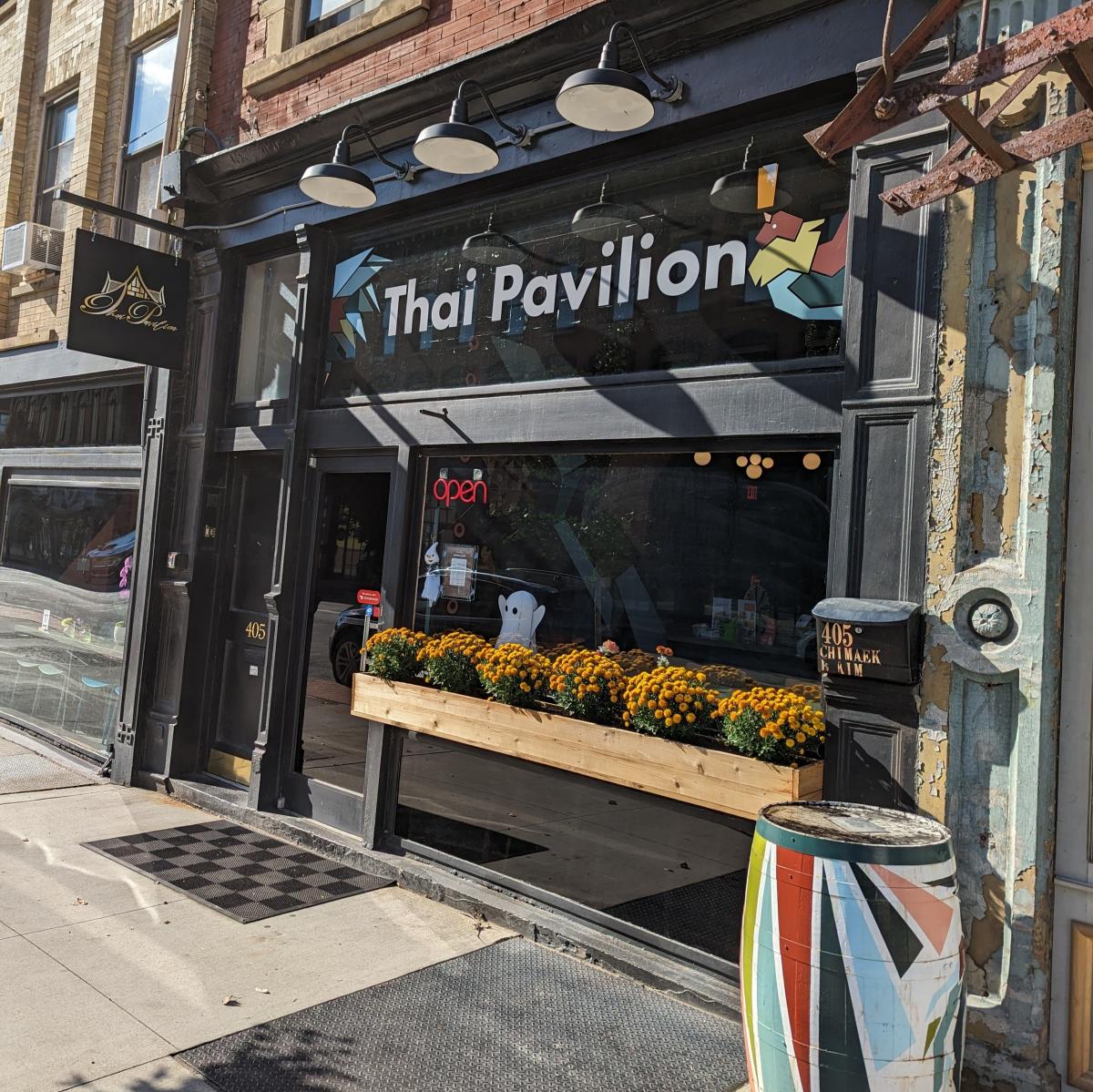 The image is an exterior shot of Thai Pavilion with a flower box in the window.