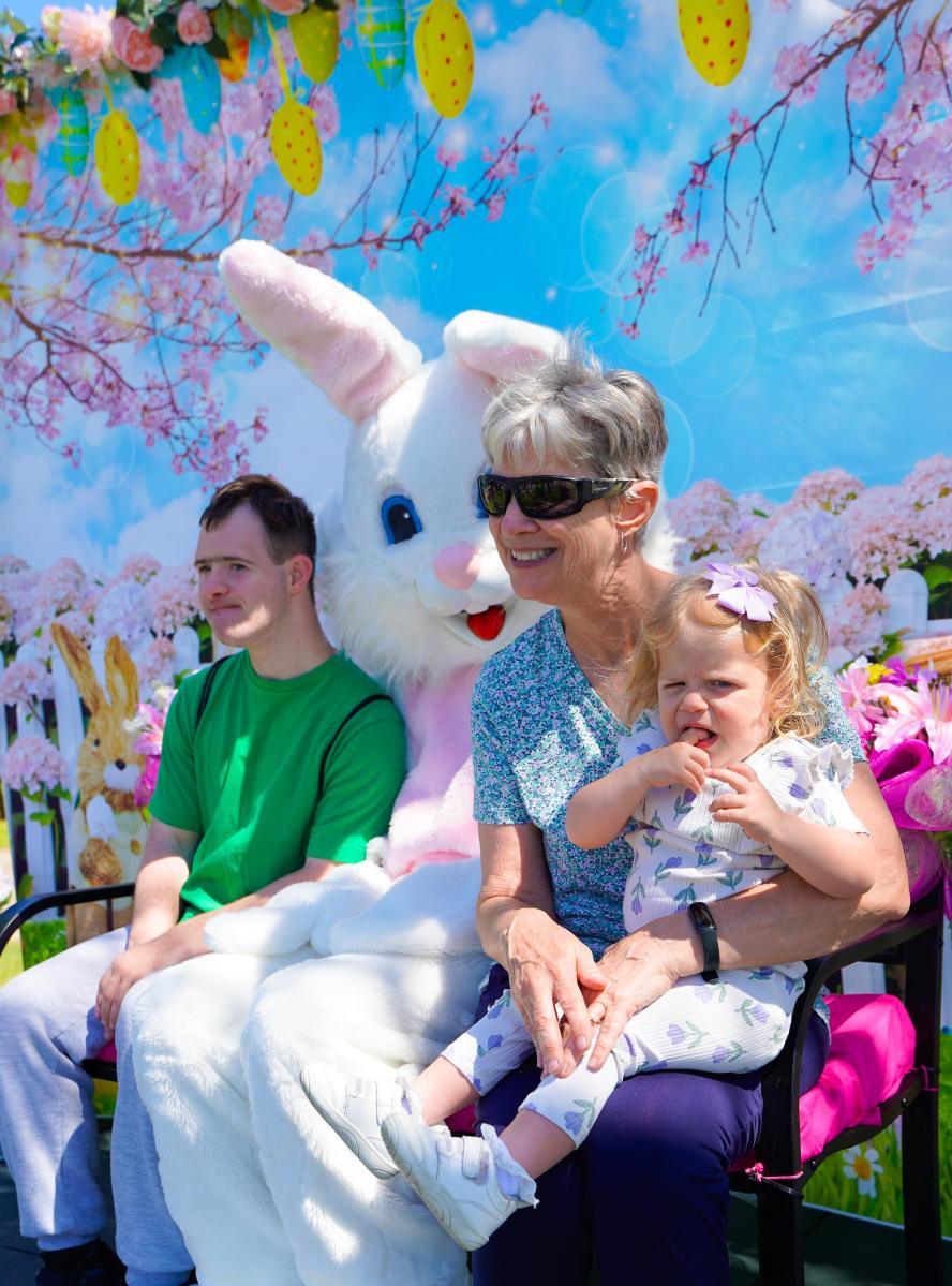 A woman, a young boy and a toddler pose for a photo with the Easter Bunny at Mandeville Community Market's annual spring event.