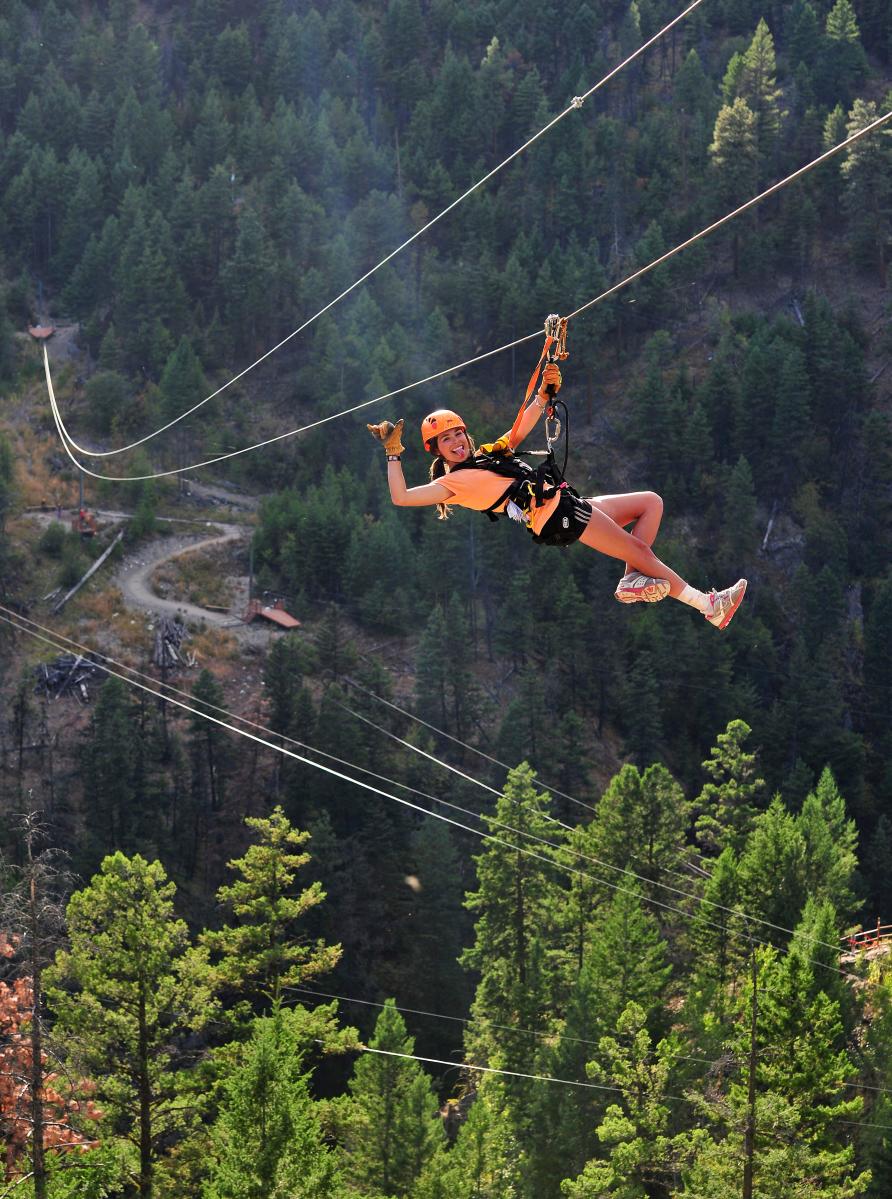 A woman rides a zipline at ZipZone Adventure Park in Peachland, BC