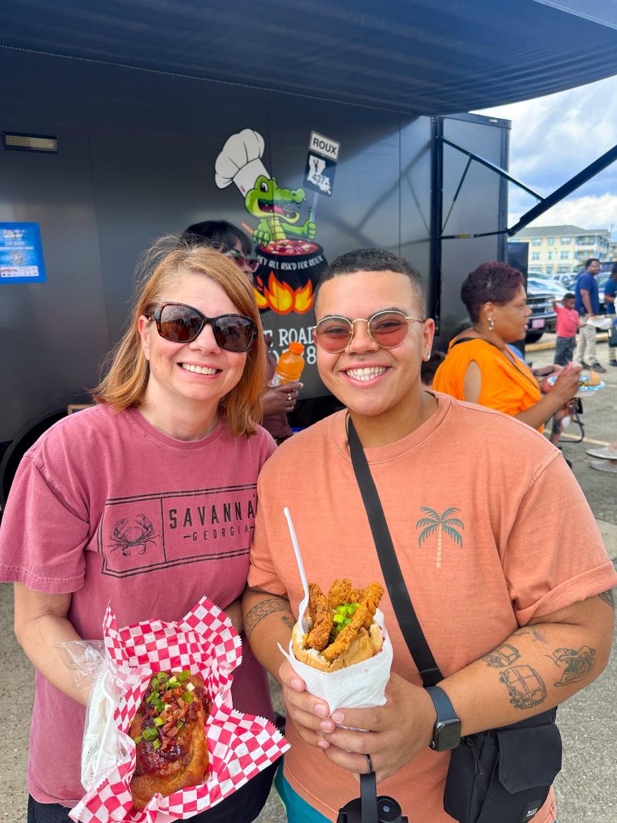 Two women hold their selections from a food truck at the Louisiana Food Truck Festival at The Harbor Center in Slidell.