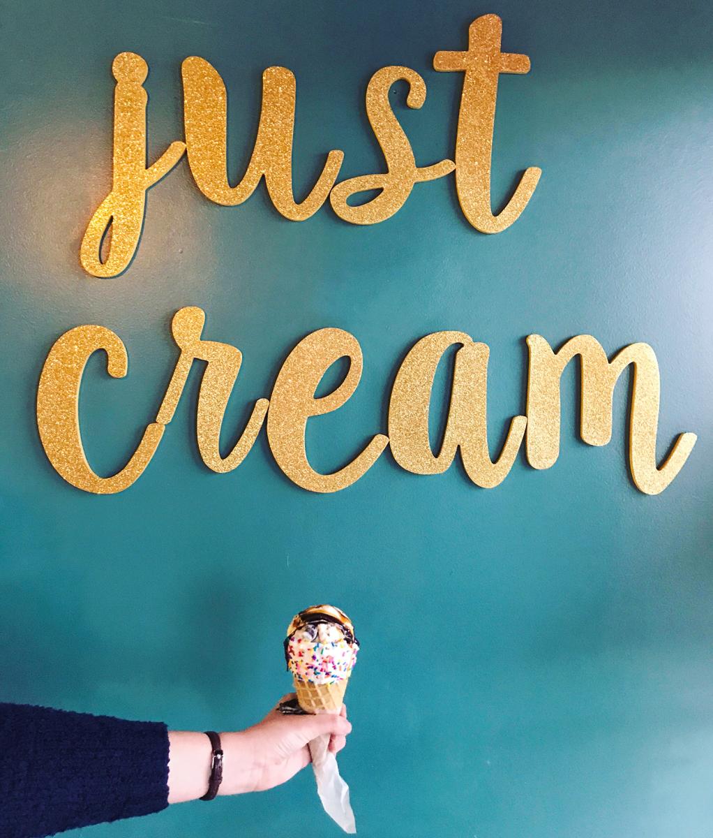 Hand holding ice cream cone at Just Cream Ice Cream Boutique in Fort Wayne