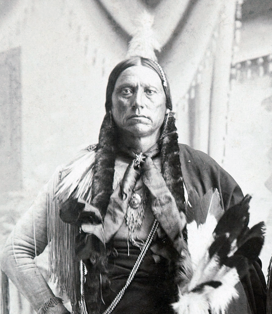 Man with long braided hair in traditional comanche outfit