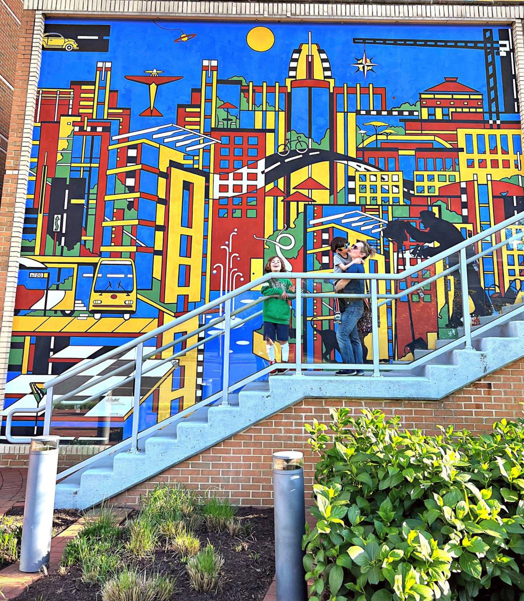 Two boys and mom posing in front of public art.