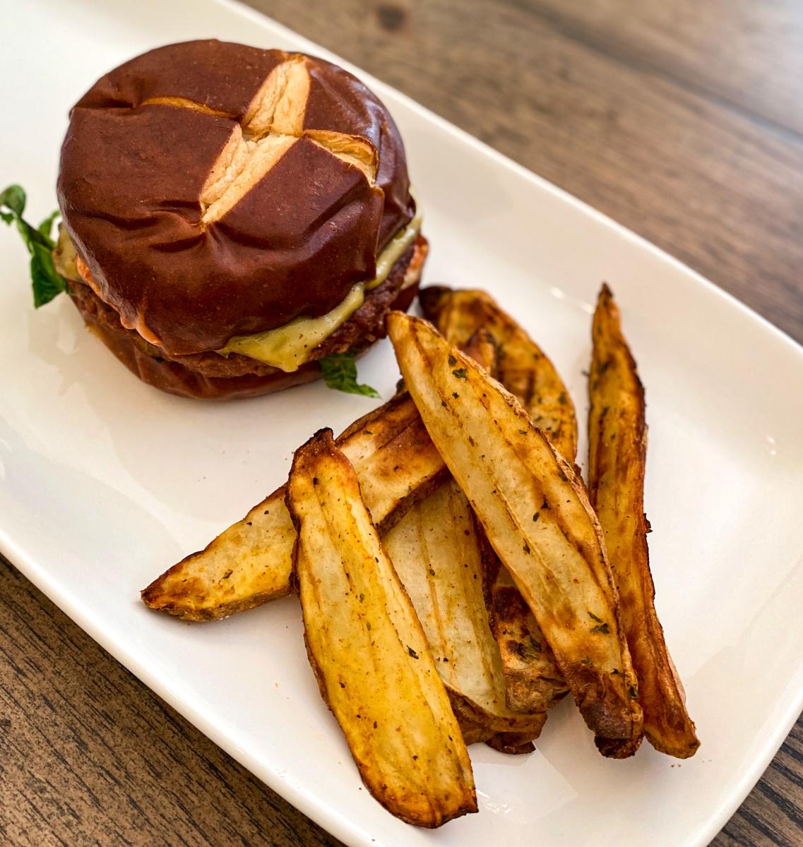 Plated vegetarian burger and potato wedges from Taste and See.