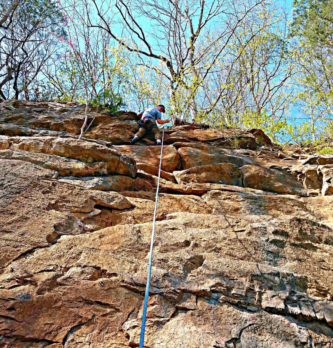 climber atop a rocky bluff