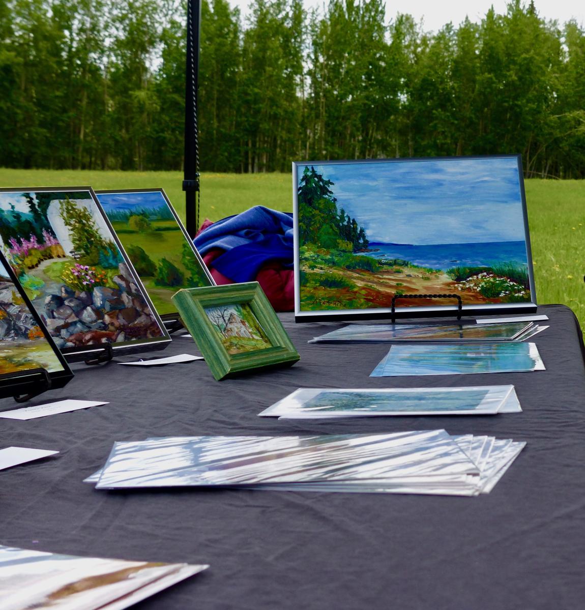 Landscape paintings on an event table in a green park