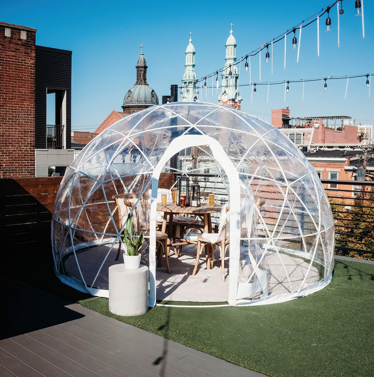 Daytime photo of clear plastic igloo on the rooftop of Braxton Brewing.