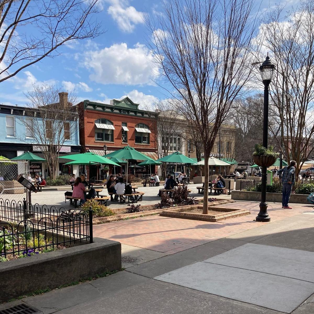An image of college square (the area of College ave that's closed in for pedestrians only) shows several picnic tables with patrons.