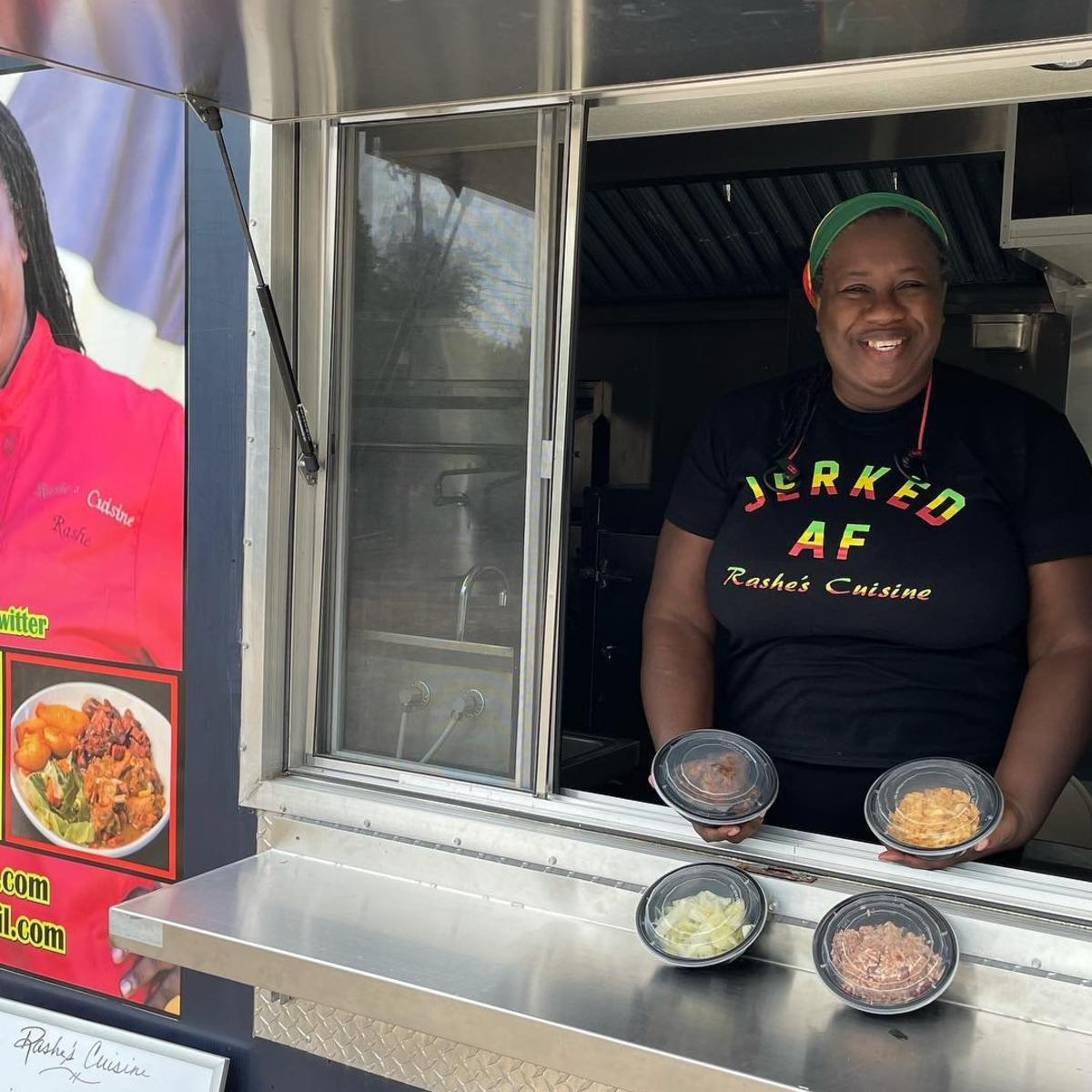 Owner of Rashe's Cuisine Rashe Malcolm serves food in the Rashe's Cuisine food truck.