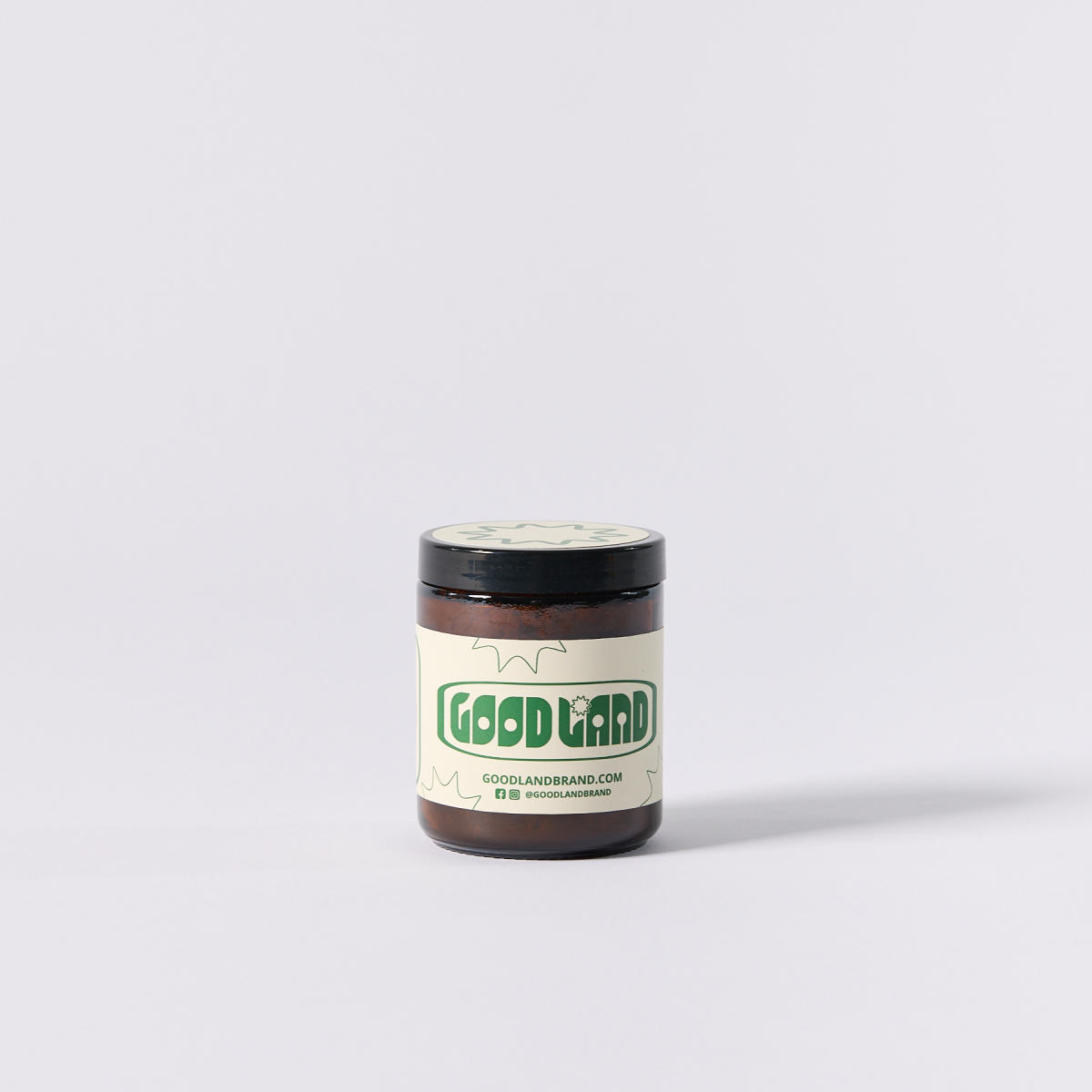 Jar of Good Land body scrub on a grey background